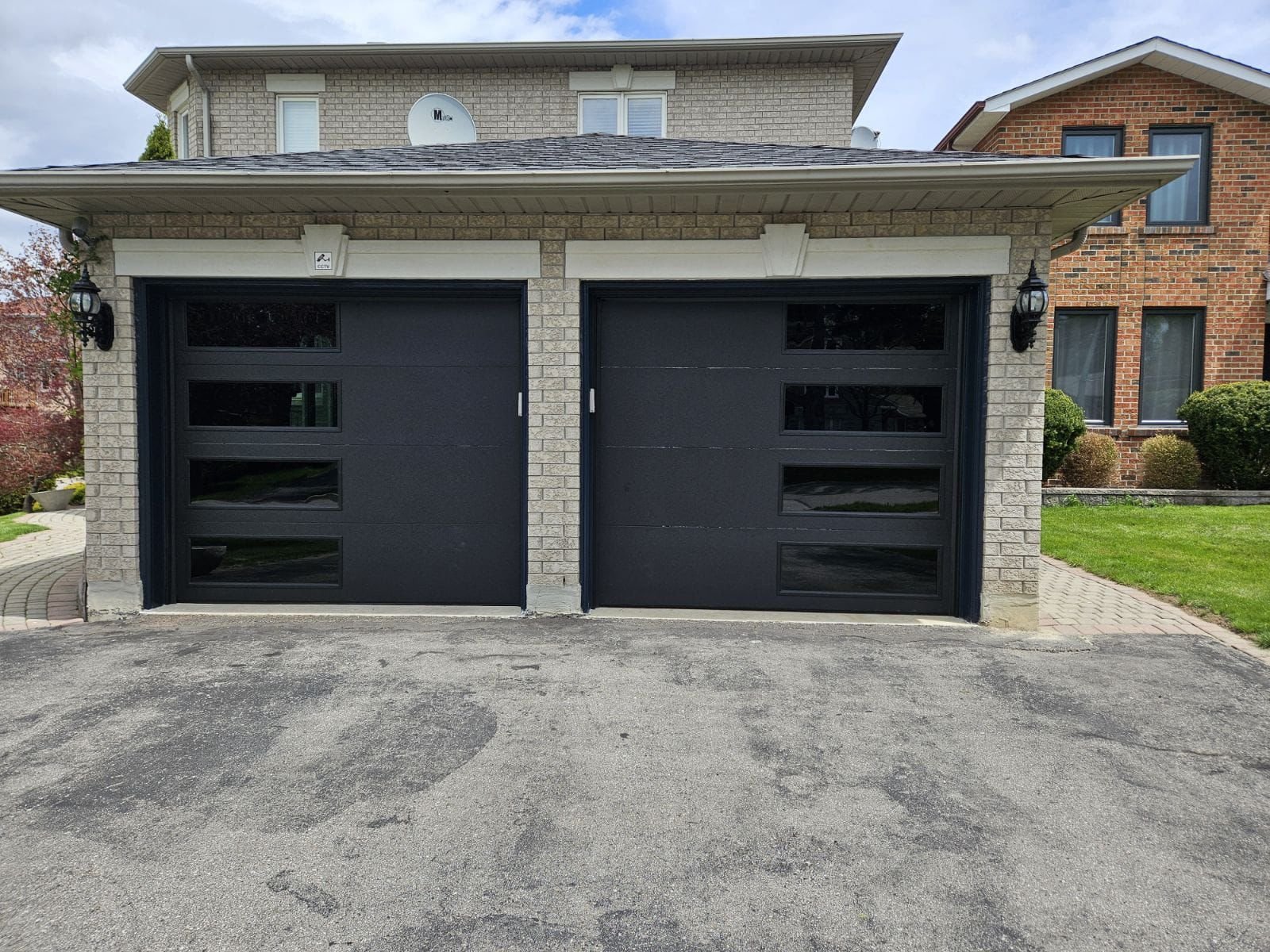 Two modern black garage doors with vertical glazed window columns